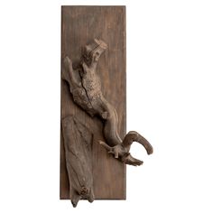 an animal sculpture is mounted on a wooden panel with two pieces of wood attached to it