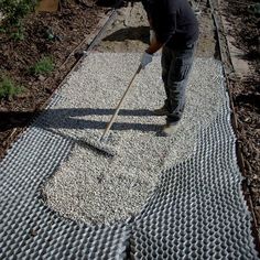 a man standing on top of a pile of gravel next to a metal grate