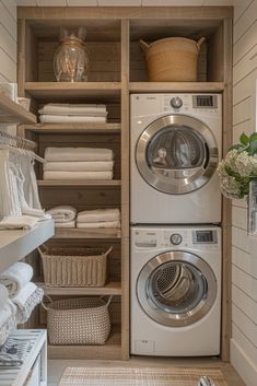 a washer and dryer in a small room with shelves on the wall above them