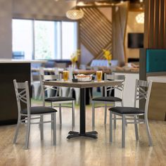 a table with four chairs around it in a room filled with tables, chairs and couches