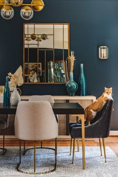 an orange and white cat sitting on top of a chair in front of a dining room table