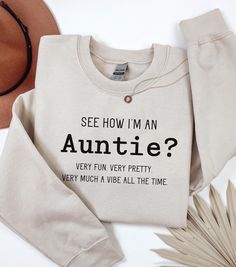 Welcome to our cozy corner of Etsy, where style meets sass with a touch of sweetness! Our Demure but Funny Auntie Sweatshirt is the perfect blend of elegance and humor--just like your favorite auntie. Crafted for those who cherish subtle sophistication with a wink of wit, this sweatshirt is a must-have for any aunt who knows how to keep it classy while sharing a laugh. .: Made with a medium-heavy fabric blend of 50% cotton and 50% polyester (8.0 oz/yd² (271.25 g/m this sweatshirt feels cozy and is the perfect choice for those colder months. .: The classic fit along with the crew neckline deliver a comfy wearing experience with a clean-cut style. Meanwhile, the double-needle stitching at the shoulder, armhole, neck, waistband, and cuff seams add top-tier durability.  .: Say goodbye to itchi Auntie Sweatshirt Ideas, Gifts For Aunts Diy, Aunt Outfits, Aunt Aesthetic, Auntie Sweatshirt, Gifts For Aunts, Auntie Life, Aunt Quotes, Christmas Gifts For Aunts