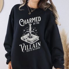 Villain Sweatshirt Book Lover Shirt Enemies To Lovers Dark Romance Bookish Things Romantasy Reader Spicy Books Dark Academia Crewneck A cozy crewneck for the villain lovers!  The perfect sweatshirt for dark romance readers.    * Q U I C K * F A C T S * ✺ 50% cotton, 50% polyester ✺ Classic fit (size up for an oversized fit) ✺ 1x1 athletic rib knit collar with spandex ✺ Inside out and wash and dry normally (on cool for best results). Do not iron decoration. ✺ Printed using DTG Direct to Garment printing.  ✺ Colors may vary due to computer monitors and printing inks. ✺ While we offer several shirt colors some may have a better contrast with the design. Keep that in mind when choosing your color.  * S I Z I N G * ✺ Sizing is unisex so runs like men's, though not overly large ✺ Size guide and Books Dark Academia, Bookish Crew Neck Top With Character Print, Bookish Crew Neck Shirt With Graphic Print, Black Literary Crew Neck T-shirt, Bookish Crew Neck T-shirt With Funny Print, Bookish Crew Neck T-shirt With Graphic Print, Spicy Books, Enemies To Lovers, Comfort Colors Tshirt