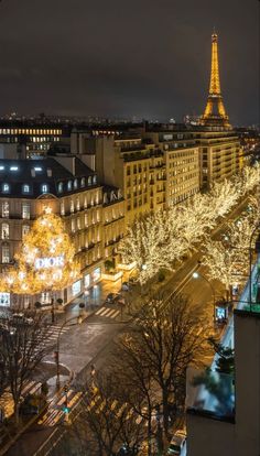 the eiffel tower is lit up at night in paris, with christmas lights all around