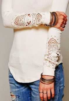 a woman wearing white sweater and lace arm warmers