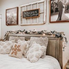 a bed with pillows and pictures on the wall above it, along with other decorations