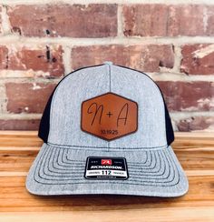 What a great way to celebrate a union, than to outfit the wedding party with hats that feature the lucky couples initials engraved into a top quality product! - Each hat is a top-quality Richardson 112 cap made fresh for you. - 13 Unique Color combos for your hat, including digitally printed camo. - 5 Different high quality leatherette patch options, made from premium materials. Ordering Instructions - In order to keep all information correct, please add each hat separately. - Select the hat col Adjustable Black Hat For Graduation, Black Adjustable Hat For Graduation, Wedding Snapback Trucker Hat, Adjustable Trucker Hat For Wedding, Custom Adjustable Wedding Hats, Adjustable Hats For Graduation, Wedding Hat With Flat Brim, Adjustable Size Flat Brim Hat For Weddings, One Size Flat Brim Hat For Weddings