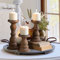 candles are sitting on a tray in front of a window