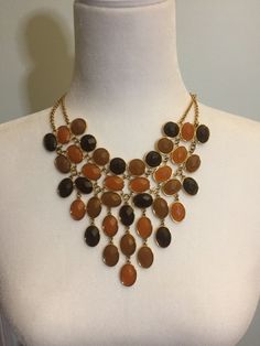 This is a vintage JOAN RIVERS earth tone brown ombre bib necklace in earth tones with goldstone settings and chain.  The beads are deep brown, beige and golden orange.  Dimensions for the necklace are shown.  There is an extender that is finished with a bead.  The JOAN RIVERS signature tag is next to the clasp. Joan Rivers Jewelry, Brown Jewelry, Brown Ombre, Bib Necklaces, Joan Rivers, Deep Brown, Bib Necklace, Brown Beige, Unique Necklaces