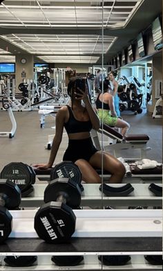 a woman sitting on top of a bench in a gym