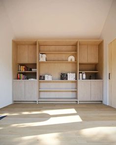 an empty room with wooden shelves and white walls