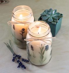 three jars with candles sitting next to each other