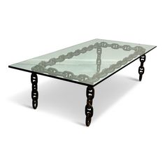 a glass and metal coffee table with chains on the legs, designed to look like chain links