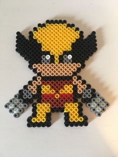 a lego figure made out of black, yellow and red beads on a white surface