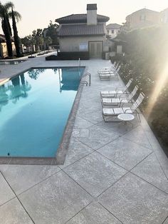 an empty swimming pool surrounded by lawn chairs