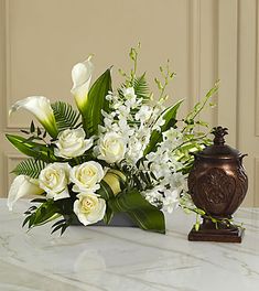 a vase filled with white flowers sitting on top of a table