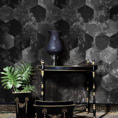 a black vase sitting on top of a table next to two planters