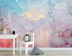 an artistic wall mural with pink, blue and gold paint on the walls in a child's room