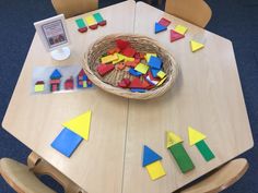 a wooden table topped with lots of different colored blocks and shapes on top of it