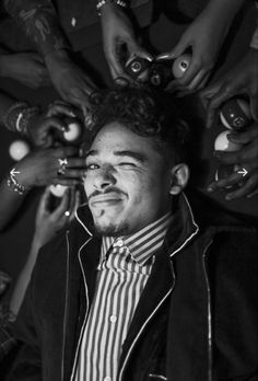 a black and white photo of a man surrounded by other people holding balls in his hands