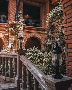 an old brick building with ivy growing on the balcony and balconies above it