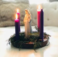 a nativity scene with three lit candles on a table in front of a couch