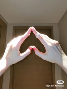 two hands making a heart shape with their fingers