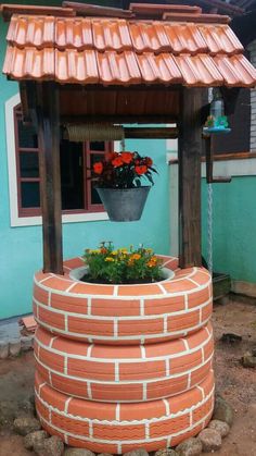 a potted plant sitting on top of a brick wall next to a gazebo