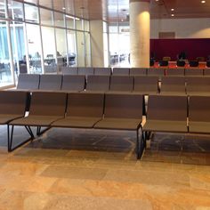 rows of empty chairs sitting in front of a large window at an airport or conference center