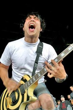 a man with his mouth open while playing an electric guitar