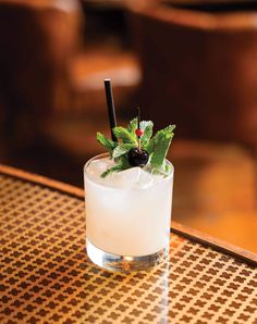 a glass filled with ice and garnish on top of a table