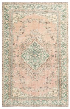 an antique rug with green and pink colors