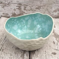 a white and blue bowl sitting on top of a wooden table