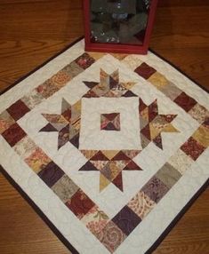 a quilted table topper with a red box on the floor next to it