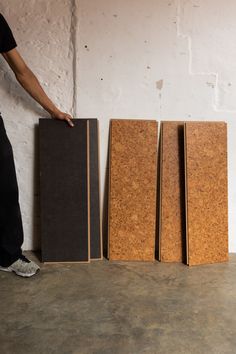 a man standing next to three speakers in front of a wall