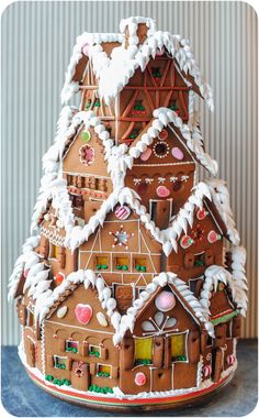 a large gingerbread christmas tree made to look like a house with snow on top