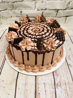 a chocolate cake sitting on top of a white plate covered in icing and toppings