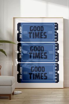 two blue signs with good times written on them in front of a white couch and chair