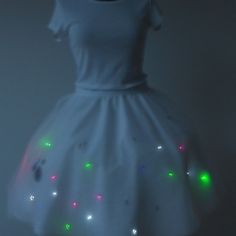 a white dress with multicolored lights on it's chest and skirt is shown