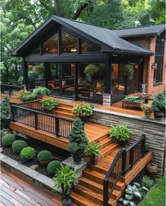 a deck with plants and potted trees on it