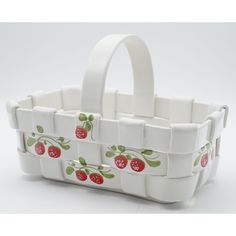 a white basket with strawberries painted on the side and handles, sitting on a table