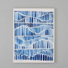 a blue and white painting on a gray wall