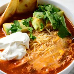 a white bowl filled with soup and sour cream