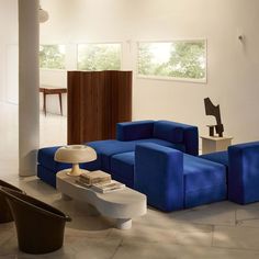 a living room filled with blue couches next to a white table and two chairs