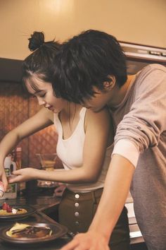 two people are preparing food in the kitchen