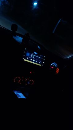 the interior of a car at night with its lights on and dashboard illuminated by blue light