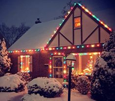 a house covered in christmas lights and snow