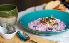 a bowl of oatmeal with nuts and blueberries in it on a table