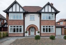 a large brick house with white trim on the windows and doors is pictured in this image