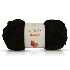 a ball of yarn that is black and has an orange dog on the front end